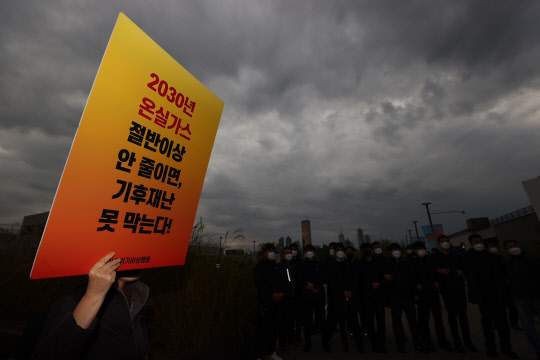 지난 18일 탄소중립위원회 전체회의가 열린 노들섬 다목적홀 건너편에서 기후위기비상행동 등 환경단체 회원들이 회의를 마치고 나오는 정부 관계자들을 향해 감축 시나리오 전면 재수립 등을 요구하며 항의하고 있다. 기사와는 관계 없음. 연합뉴스